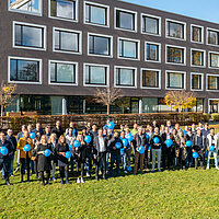 Gruppenbild der meteocontrol Mitarbeiter und Mitarbeiterinnen vor dem neuen Bürogebäude in Augsburg